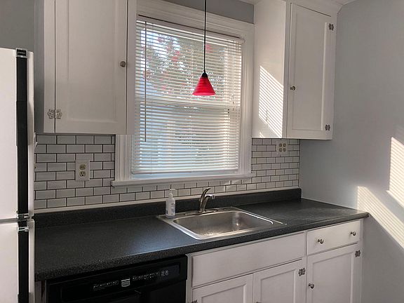 Kitchen with white cabinets & white subway tiles.