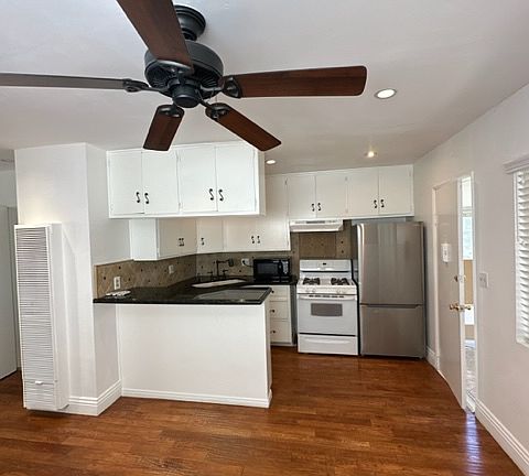 Just another view of the living room, space, kitchen and floors with your ceiling fan.
