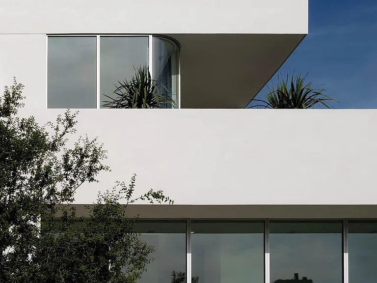 Curved Glass Softens Building Edges _ Curved floor-to-ceiling glass blurs the boundary between interior and exterior, offering expansive views while maintaining privacy through strategic architectural framing.