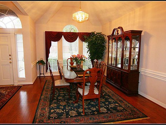 Large formal dining room with beautiful views.  Hardwood floors, custom drapes, and double chair railing.