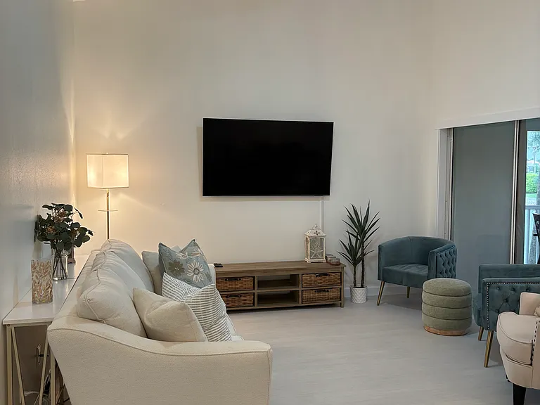 Living room with new 65" TV and comfortable couches and chairs