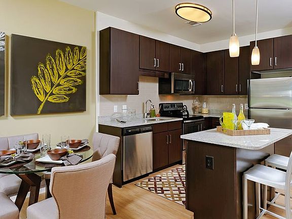 Dining area and kitchen with granite countertops, stainless steel appliances, tile backsplash, island and hard surface flooring