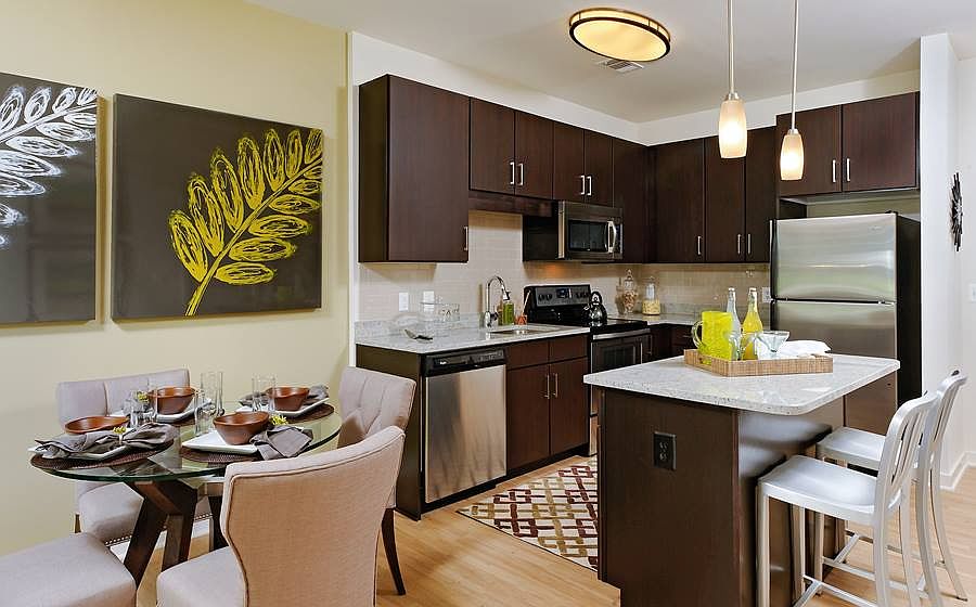 Dining area and kitchen with granite countertops, stainless steel appliances, tile backsplash, island and hard surface flooring