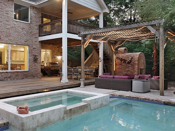 A wood burning pizza oven, outdoor kitchen, heated pool, spa and wooded surroundings offer an incomparable outdoor lifestyle.