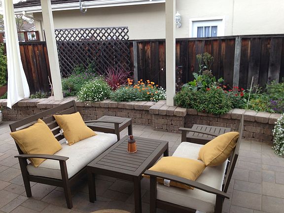 Large landscaped backyard with porch, fruit trees.