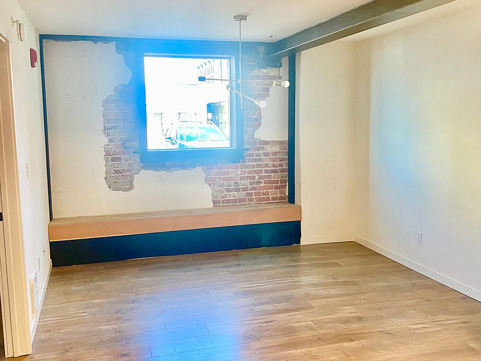 built in bench under window in the living room with exposed brick and plaster
