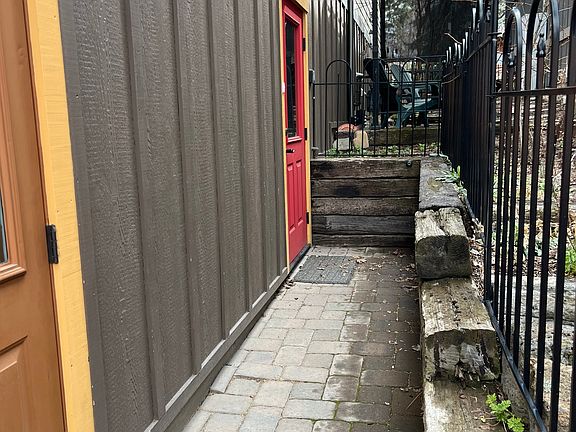 Red door is the entrance to the ADU/apartment. There is a small side yard with a gazebo.