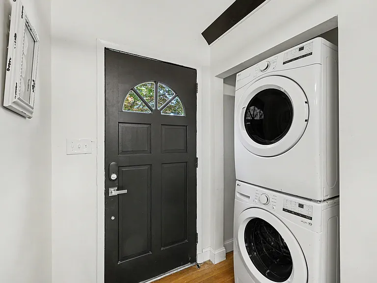 Dedicated laundry nook near the entry features a stacked front-load washer and dryer for convenient in-home washing.