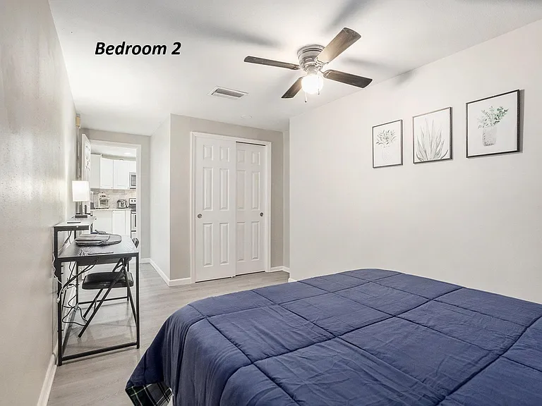 Bedroom 2 with bed, desk, chair, double-door closet & MiniFridge. Bedding may not be provided.