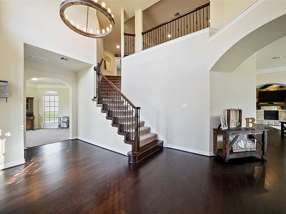 Two story entry way with stately staircase and engineered hardwood floor.