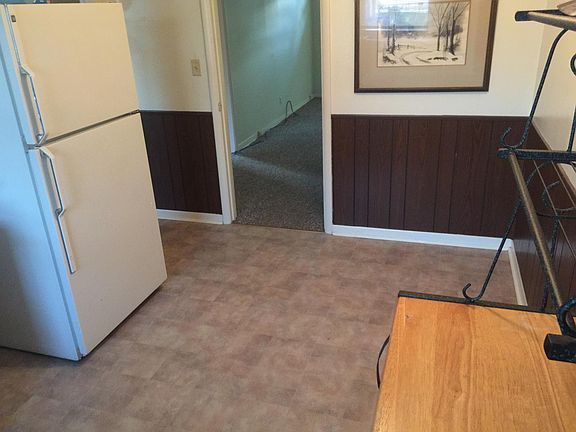 Doorway to living room. Refrigerator with ice maker.