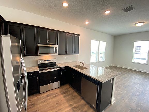 Kitchen view with family room in the background.