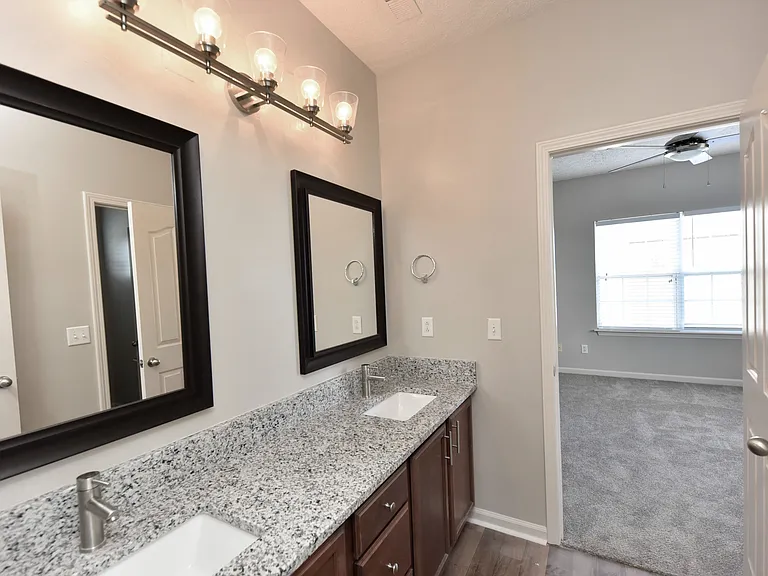 Bright bathroom with granite counters and double sinks