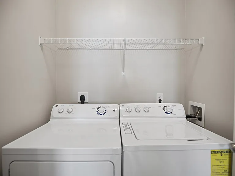 A white washing machine and dryer in a laundry room.