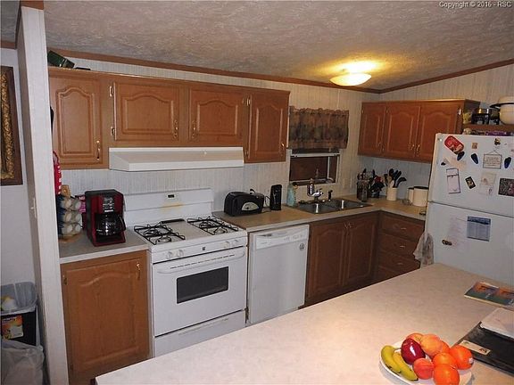 All white appliances including a gas stove, dish washer and refrigerator.