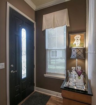 Foyer with crown molding and leaded glass front door