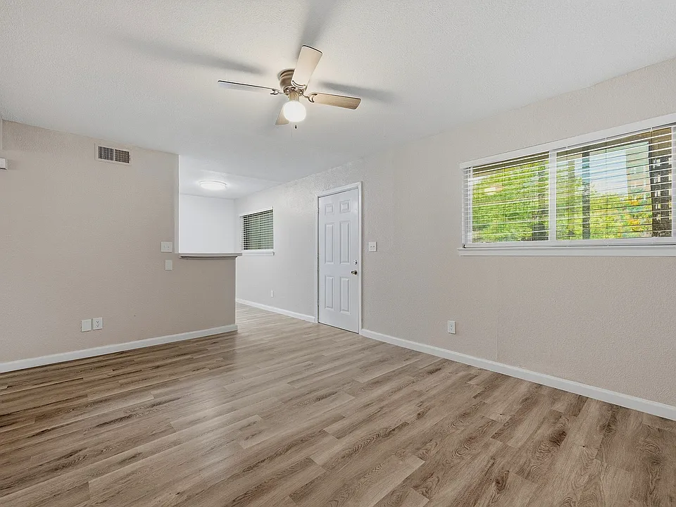 Open living room with wood-look flooring.