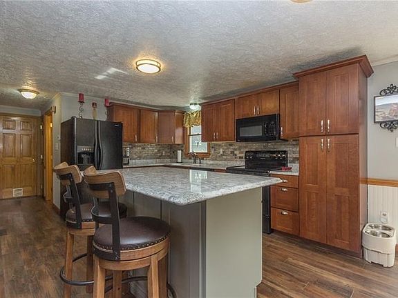 Recently Remodeled Kitchen with oak cabinetry, quartz countertops and ceramic backsplash