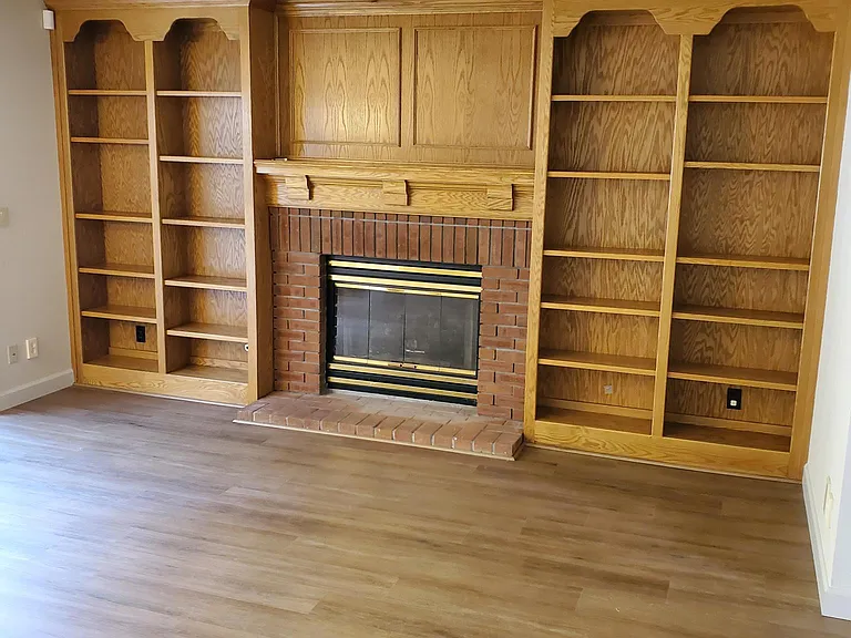 View of fireplace, and built-in bookcase from comfortable spot in family room.