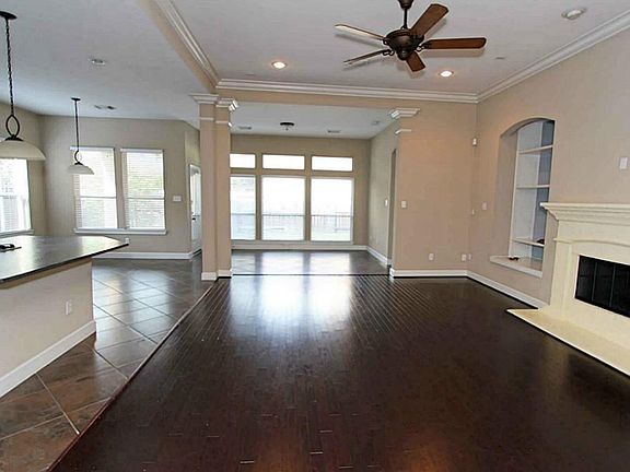 The hardwoods continue into the family room which has a fireplace and an entertainment niche. There is crown molding and recessed lighting.