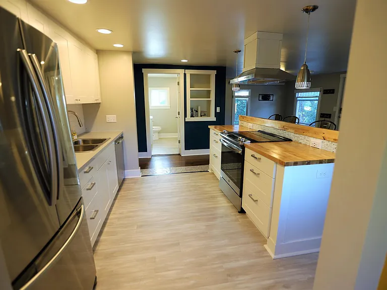 View into kitchen from mud room. New floors 2022, new appliances 2019.