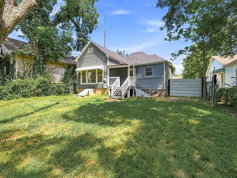 Spacious backyard featuring a sloped lawn and mature trees
