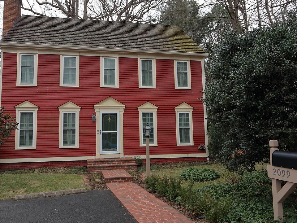 Front of house, partly showing newly asphalted parking pad. Also, new brick walkway.