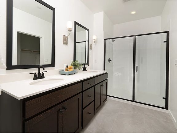 Primary bath with dual sinks and glass shower enclosure