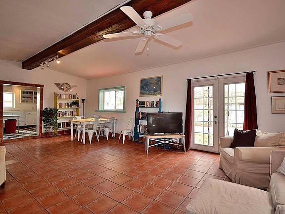 View of french doors to additional backyard space. Saltillo tile flooring throughout.