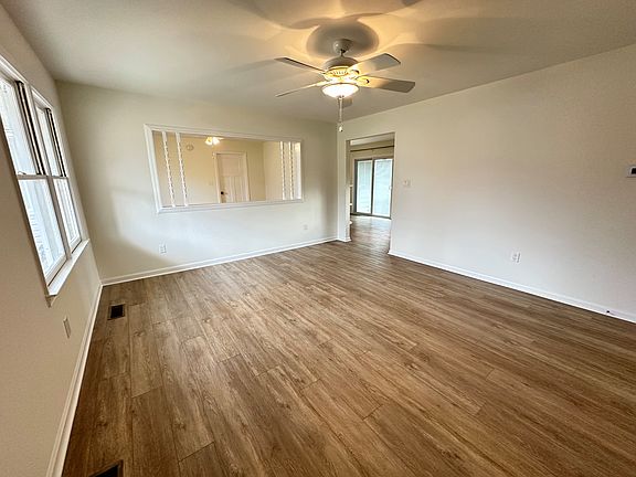 You enter the home in the living room. There's a coat closet to the right (unseen in this photo). The space features a view into a bonus room and the kitchen/dining room.