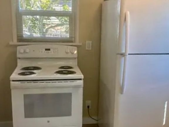 Kitchen with appliances. Alternate placement for refrigerator in kitchen available.