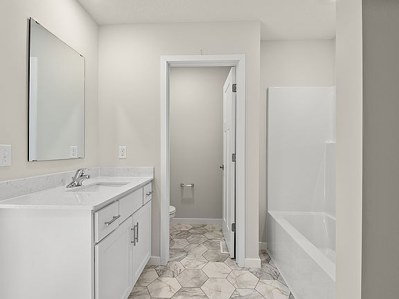 The master bathroom has a large vanity and a tub shower combo.