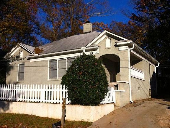 Front view of house. There is a cute front porch up the stairs. A fenced front yard and off street parking in the back.