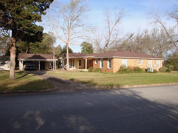 back of house showing carport, storage shed, covered deck, and mud room
