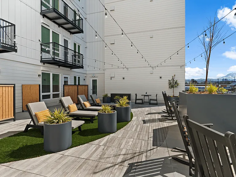 Enjoy fresh air and mountain views from a beautifully designed outdoor lounge in Sumner apartments.