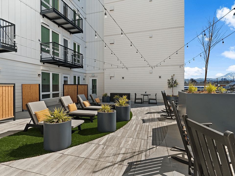 Enjoy fresh air and mountain views from a beautifully designed outdoor lounge in Sumner apartments.