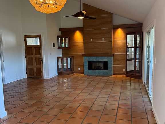 Inviting living room featuring a wood-paneled accent wall and vaulted ceilings.