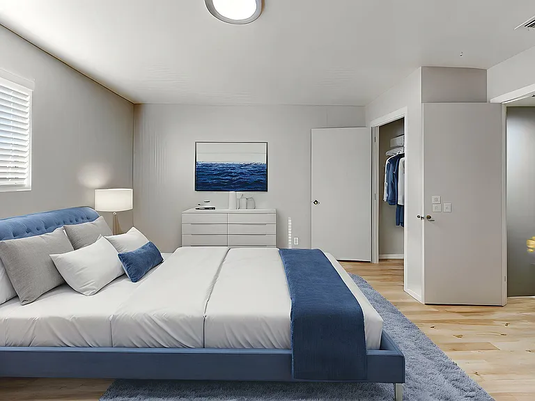 Elegant bedroom featuring a plush blue bed, modern decor, sleek flooring, and ample closet space with contemporary furnishings.