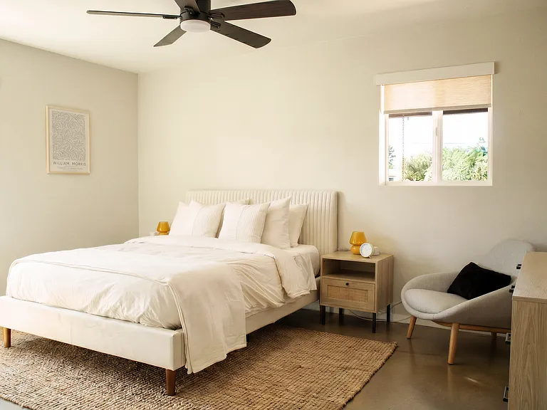 Bright bedroom with queen bed and seating area.