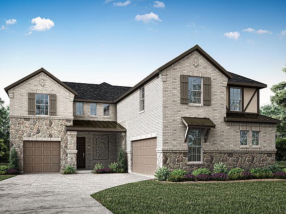 A two-story brick and stone house with a well-manicured lawn and landscaping, set against a blue sky