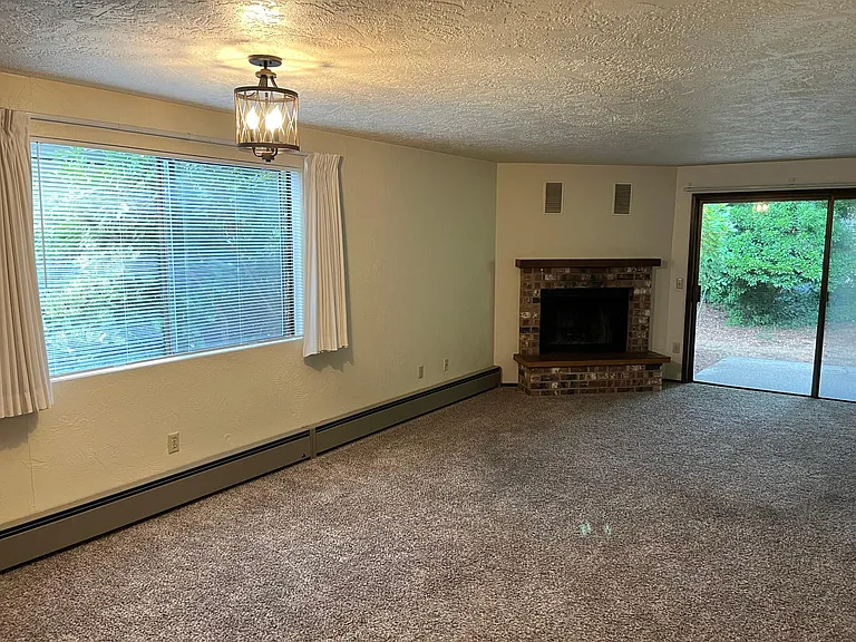 Open floor plan; oversized glass patio doors. All windows include white blinds. NOTE: Wood burning fireplace only used for emergency heat if power out (cozy radiant electric heat panels in every room).