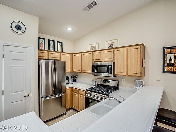 KITCHEN WITH PANTRY, CUSTOM CABINETS, BREAKFAST BAR, OPEN TO LIVING ROOM AND DINING AREA.