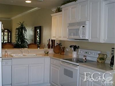 Kitchen with raised panel cabinets and solid surface countertops. Dome ceiling with fan and a double