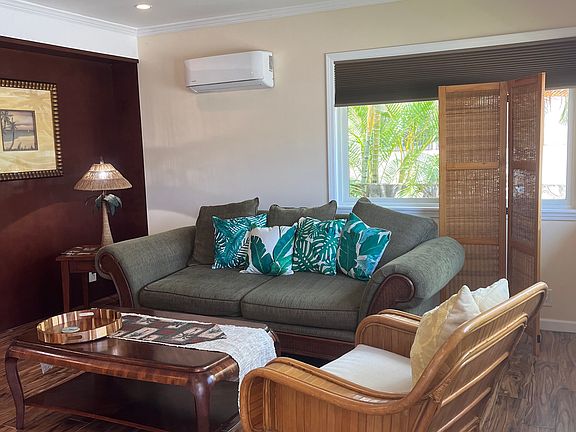 Cozy and elegant living area featuring stylish furniture, a ceiling fan, and a split AC unit for ultimate comfort. Perfect for relaxing and entertaining with a smart TV