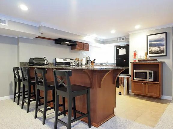 Kitchen has a spacious granite countertop breakfast bar that comfortably seats four.