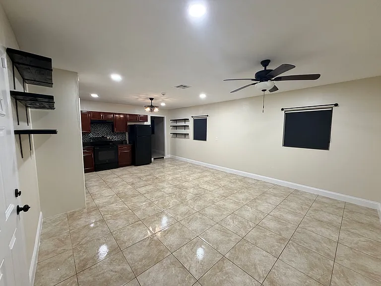 The open_concept living room offers bright windows with blackout shades and warm recessed lighting throughout the space. (Angle 1)
