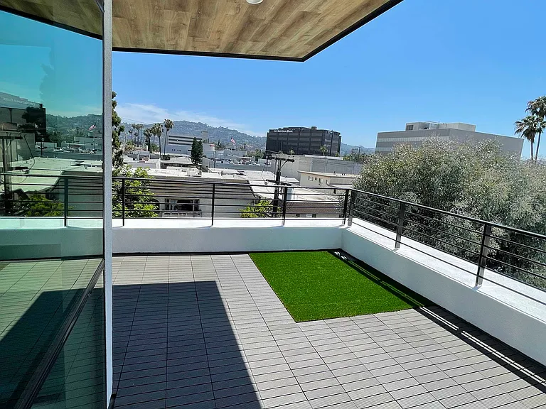 Private rooftop patio with decking and pet friendly synthetic turf. Shaded cantilever with dimmable led lighting. Sunset views.