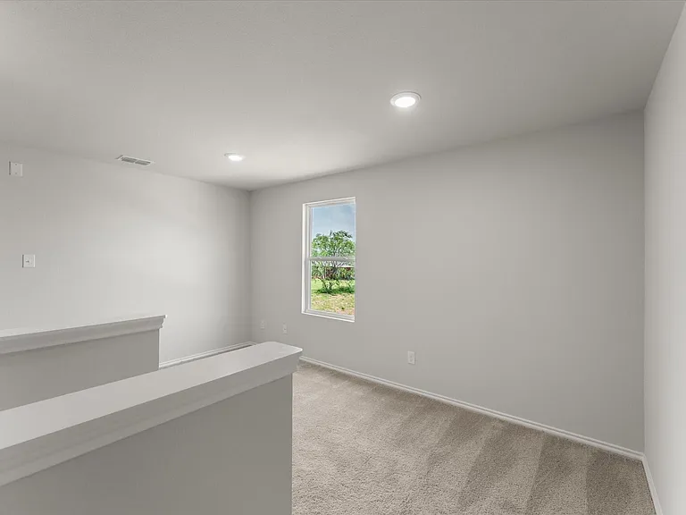 Carpeted landing area featuring a window, recessed lighting, and white trim