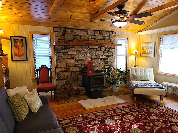 Living room with stone fireplace and wood stove.