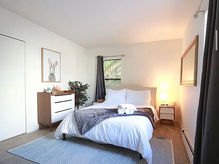 First-floor bedroom. Unit is offered unfurnished; furnished photo included to provide a sense of the room's dimensions and layout possibilities.